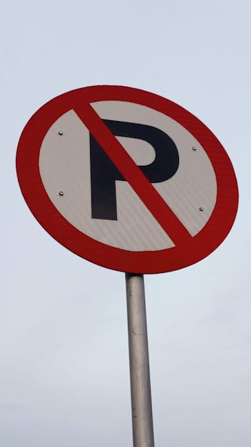 A circular traffic sign with a red border and white background, displaying a black pictogram of a person standing beside a car, indicating parking restrictions related to home relocation or moving act